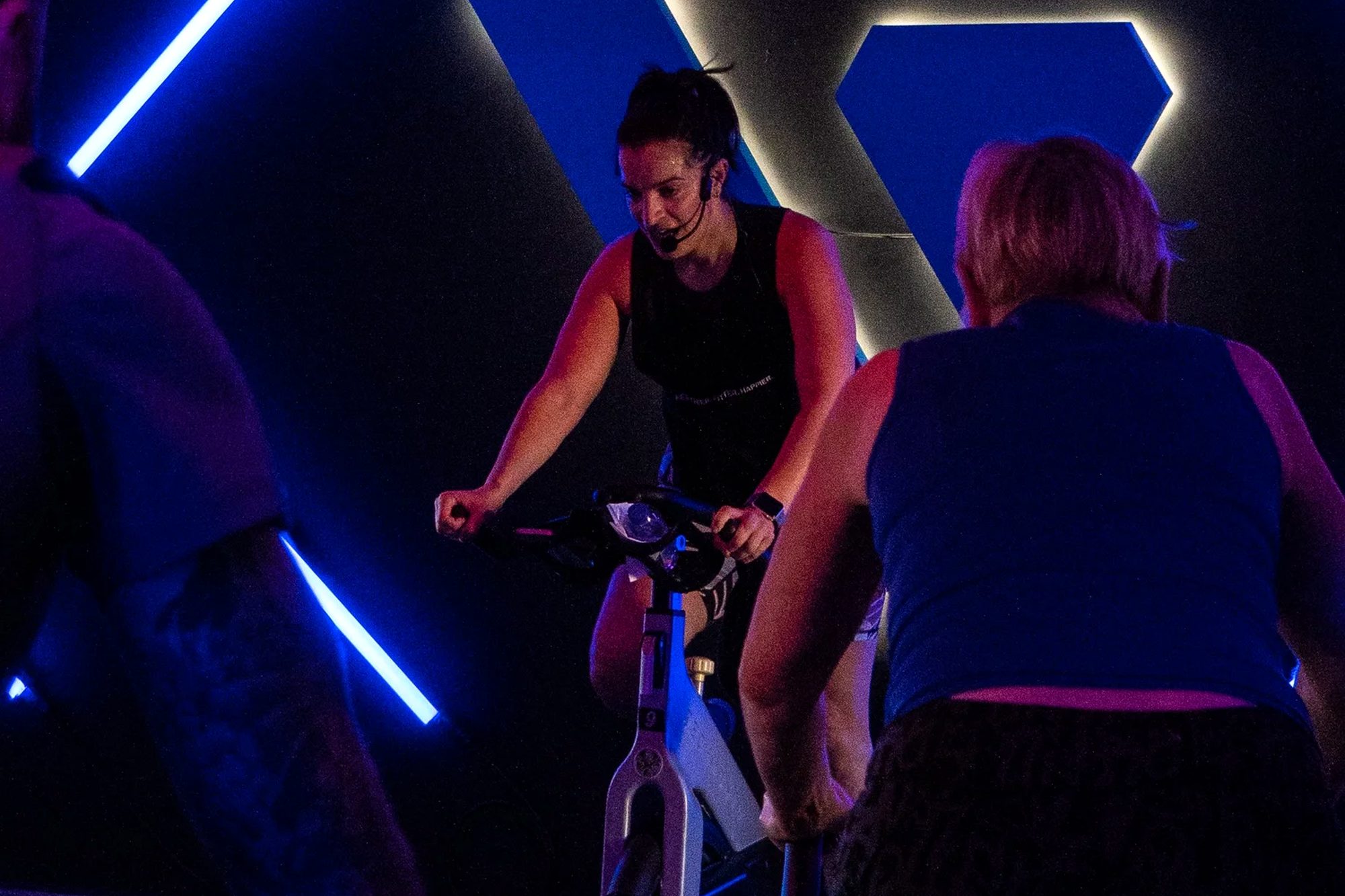 Group cycle session in a dark studio