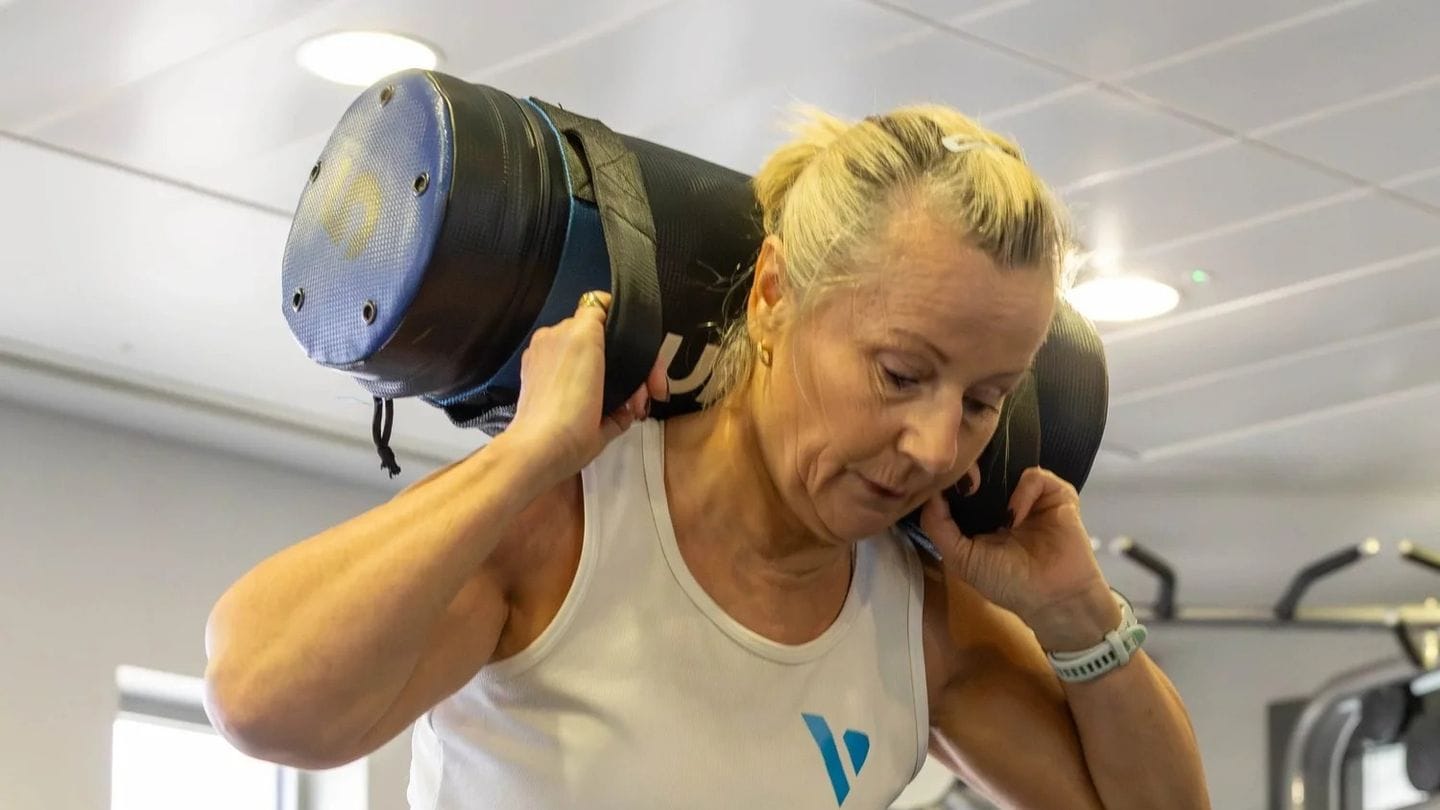 A Vision Fitness member training with a medicine ball