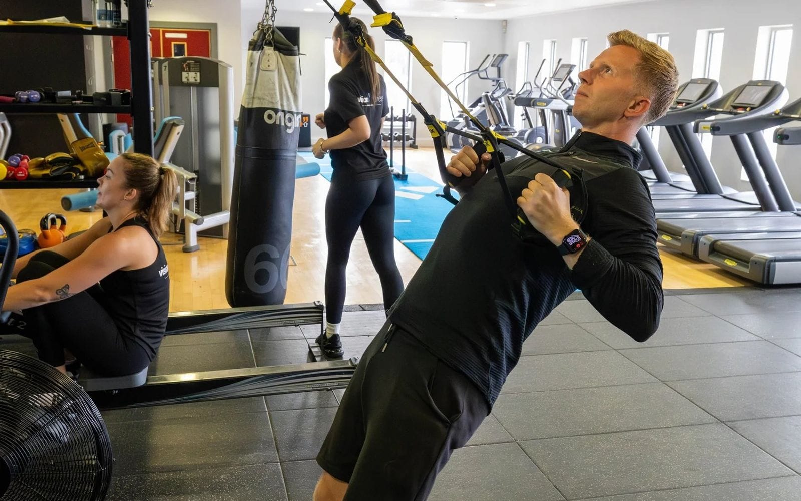 A Vision coach demonstrating suspension training on the gym floor at Leventhorpe